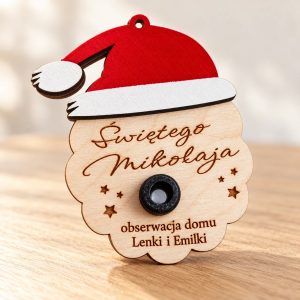 Drewniana kamera Świętego Mikołaja z czerwoną czapką, obiektywem i grawerem obserwacja domu Lenki i Emilki